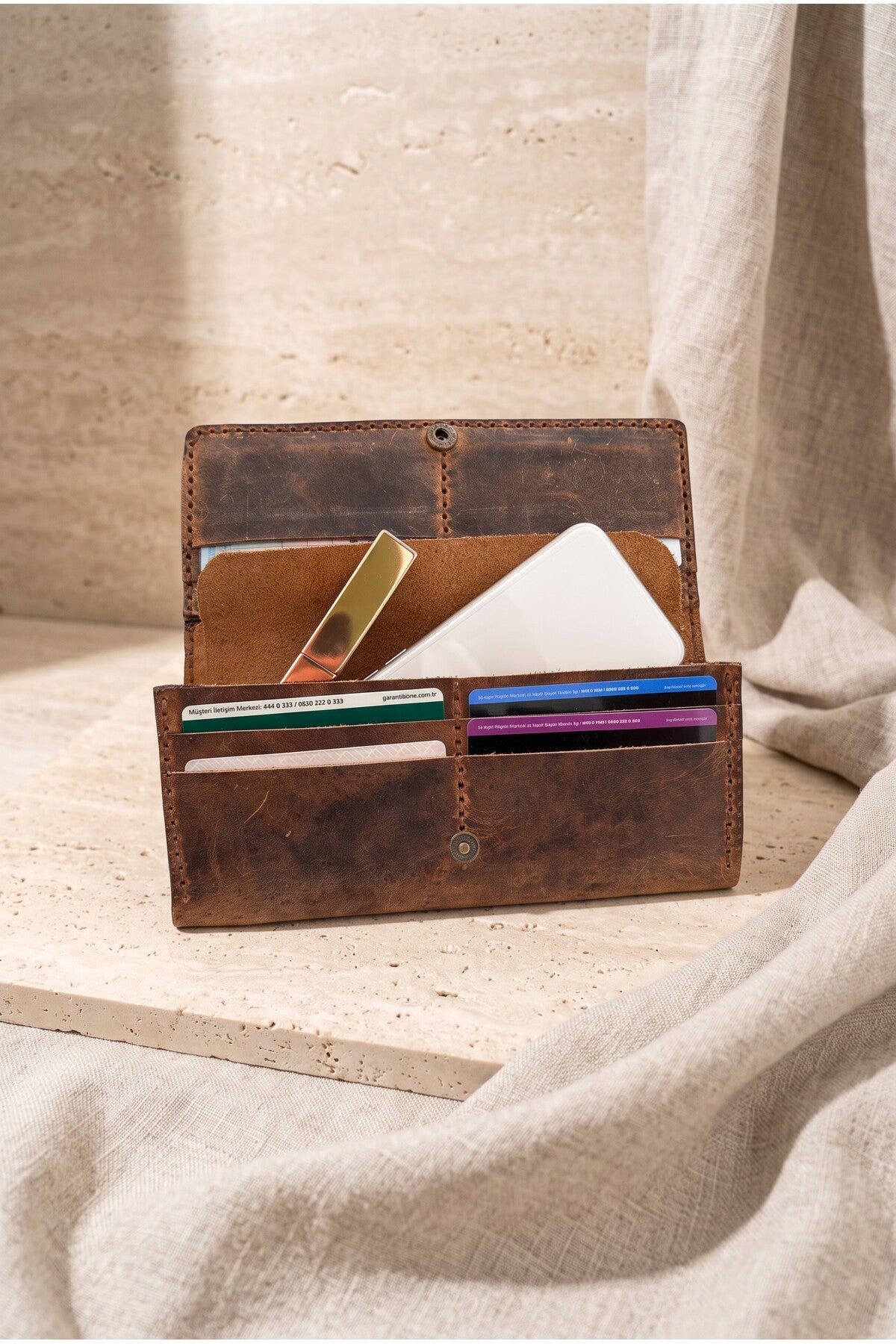 Handmade tan leather long wallet on linen