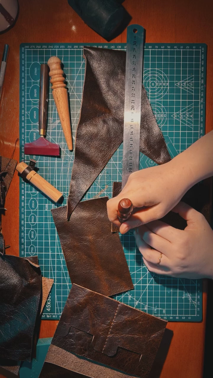 Leather being cut by hand on a cutting mat in the design 25.07 atelier